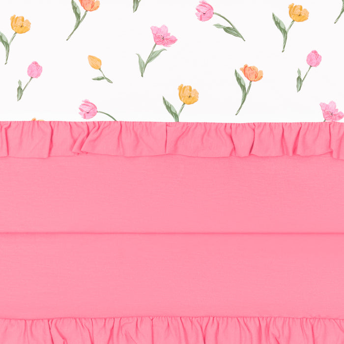 Close up of the Ruffle Toddler Blanket in Tulip 0.5 showing the pink packing, ruffled edges and floral print top layer