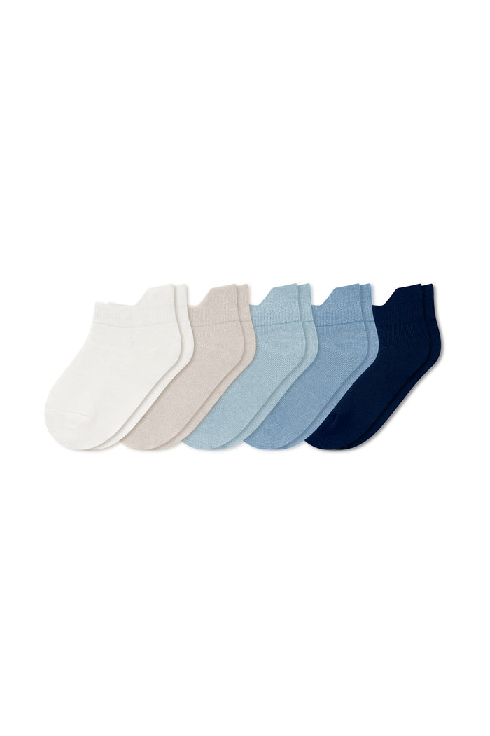 Five pairs of ankle socks in Nay, Slate, Fog, Oat, and Cloud laying flat on a white background.