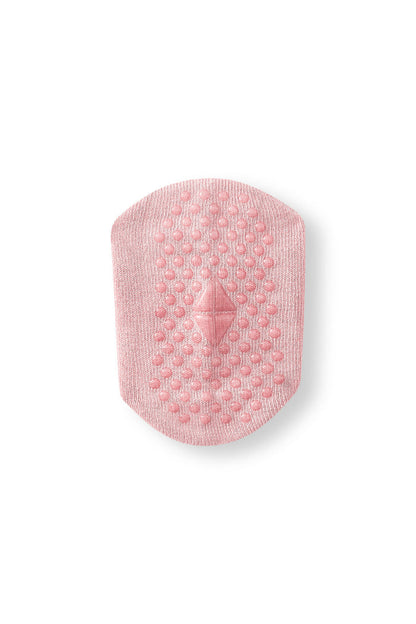 Bottom of a sock int he color blush with grips.