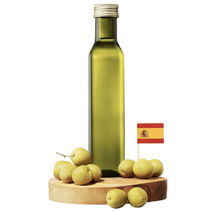 A clear bottle of Arbequina Extra Virgin Olive Oil with a wooden base, surrounded by small green olives and a small Spanish flag.