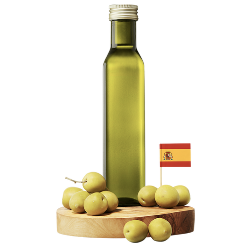 A clear bottle of Arbequina Extra Virgin Olive Oil with a wooden base, surrounded by small green olives and a small Spanish flag.