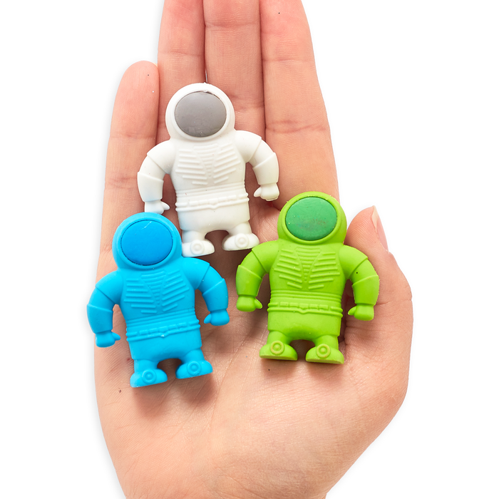 Blue, white and green astronaut erasers in the palm of a hand