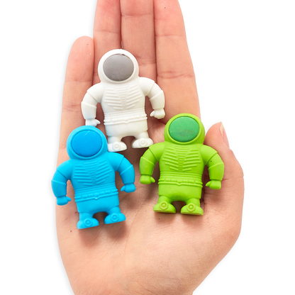 Blue, white and green astronaut erasers in the palm of a hand
