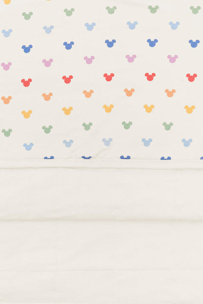 Back side fabric of baby blanket with pastel mickey mouse icons on an oat background