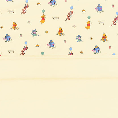 Close up of the Baby Blanket in Winnie the Pooh Celebration showing the light yellow quilted backing and smooth printed top layer