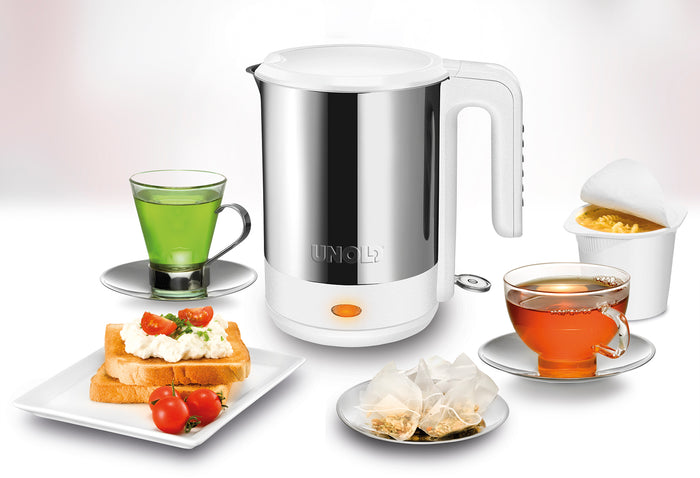 Der Unold Blitzkocher Edel 1,5 L steht auf einem weißen Hintergrund, umgeben von Tassen mit grünem und schwarzem Tee, Toast mit Sahne und Kirschtomaten, Teebeuteln auf einem Teller und einer Tasse Instantnudeln.