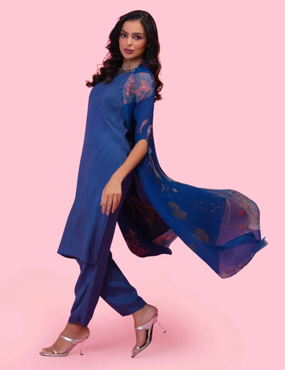 Model wearing the 'BRAHMAND BLUE' kurta set with a straight-fit Dola silk kurta, matching pants, and a statement printed georgette cape.