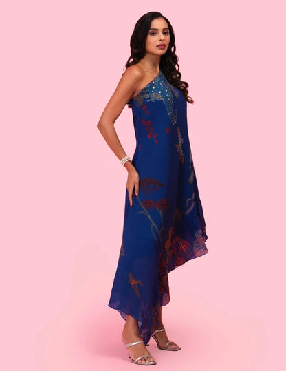 Model wearing the 'BRAHMAND BLUE' ONE SHOULDER DRESS featuring micro-pleated georgette, delicate hand embroidery, and a nature-inspired artistic print in Singapore.
