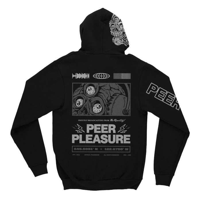 Back of black full zip hoodie. PEER PLEASURE written in white lettering with lightening bolts on the top corners of both sides. A design of a skull wearing headphones with three eyes is above the text. Above the drawing is the soundwave, globe, and barcode drawings. Below the PEER PLEASURE text is coordinates.