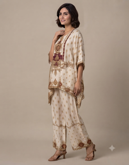 Model wearing an elegant cream-colored printed tunic and matching trousers set against a muted beige background.