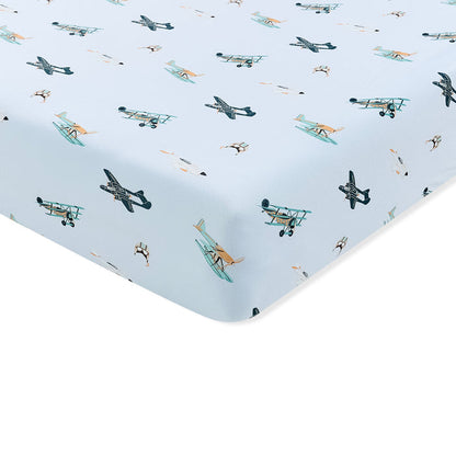 Corner of the Crib Sheet in Take Off shown on a mattress