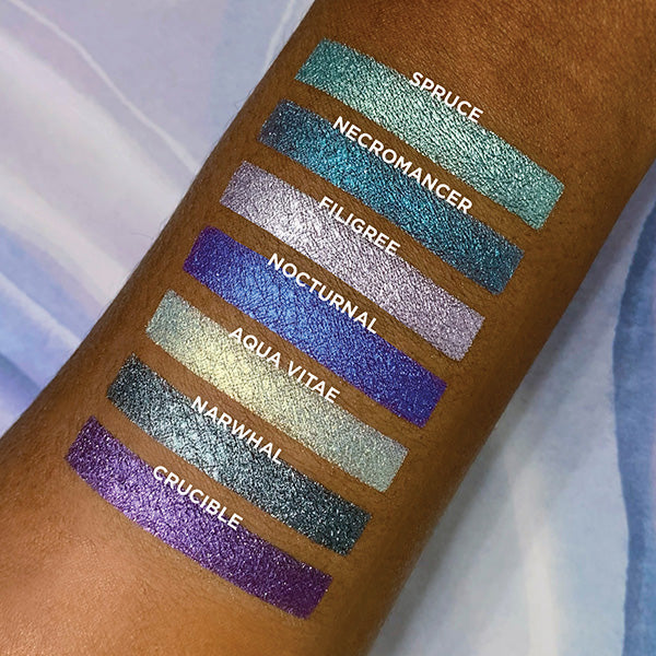Top angled arm swatches on deep skin tone of Penumbra Bundle including Spruce, Necromancer, Filigree, Nocturnal, Aqua Vitae, Narwhal, Crucible