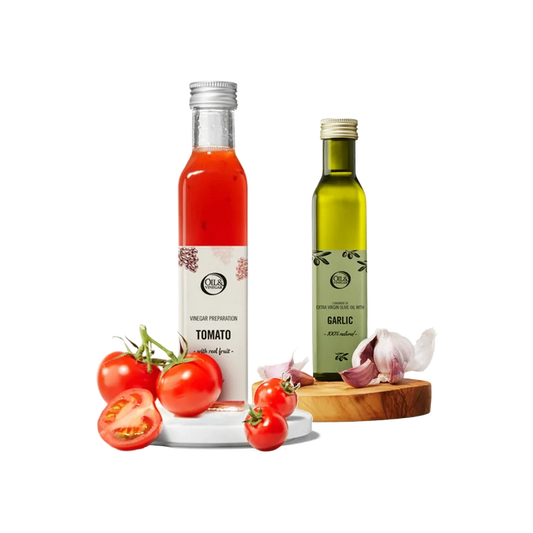 Two bottles of tomato vinegar and garlic olive oil with tomatoes and garlic