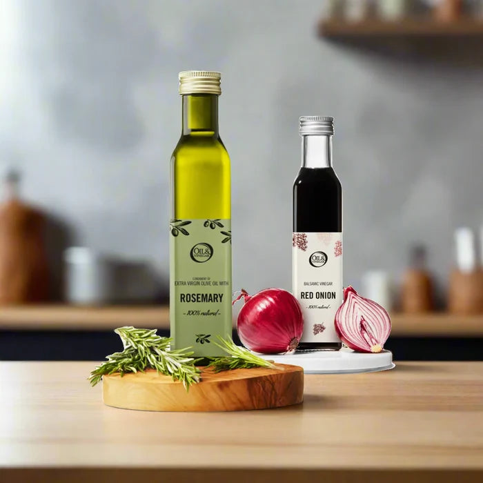 Two bottles of olive oil with rosemary and red onion on a wooden surface