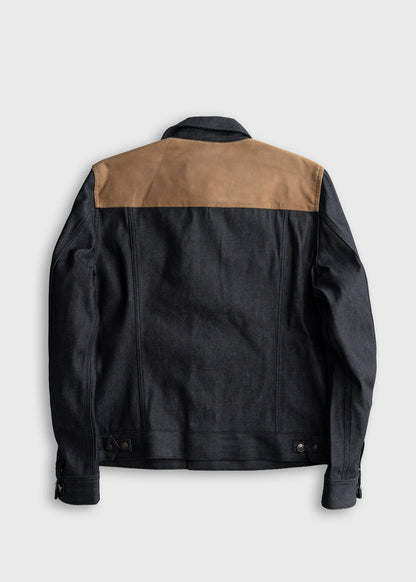 Dark denim jacket with tan shoulder panel, back view. Features adjustable cuffs and waistband, creating a stylish, modern look.