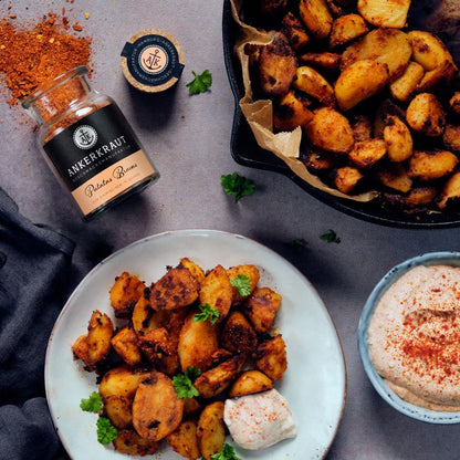 Patatas Bravas mit Dip auf einem Teller.