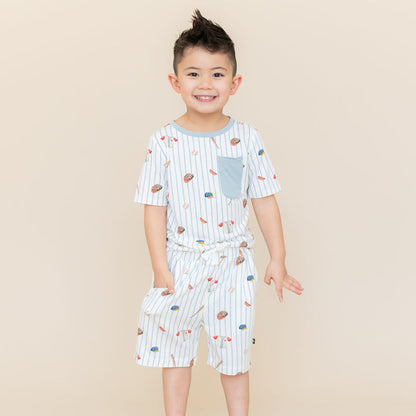 Young boy wearing the Toddler Crew Neck Tee in Home Run paired with matching Drawstring Shorts in Home Run