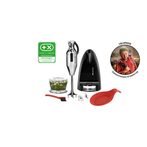 Das Stabmixer-Set Unold ESGE-Zauberstab® M 200 Chrom umfasst mehrere Aufsätze, eine mit Kräutern gefüllte Zerkleinererschüssel, einen roten Spatel, eine Reinigungsbürste, eine Wandhalterung und ein Auszeichnungsabzeichen. Ein Koch zeigt in einem Kreis mit deutschem Text den Daumen nach oben.