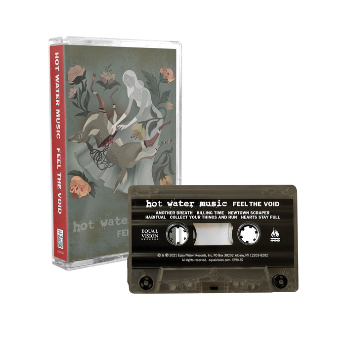 Army green cassette tape. Case has cartoon drawing of a woman and an upside-down serrated deer. Pink flowers are around the border. Background is muted green cover. Bottom of case has "HOT WATER MUSIC, FEEL THE VOID" printed.