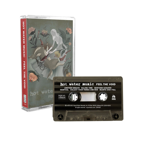 Army green cassette tape. Case has cartoon drawing of a woman and an upside-down serrated deer. Pink flowers are around the border. Background is muted green cover. Bottom of case has "HOT WATER MUSIC, FEEL THE VOID" printed.