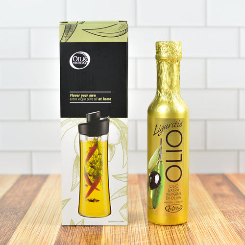 The image shows a Herb Oil Infuser Gift Set with a black and gold color scheme. The set includes a clear infuser bottle with herbs inside, a black lid, and a box with the product branding.