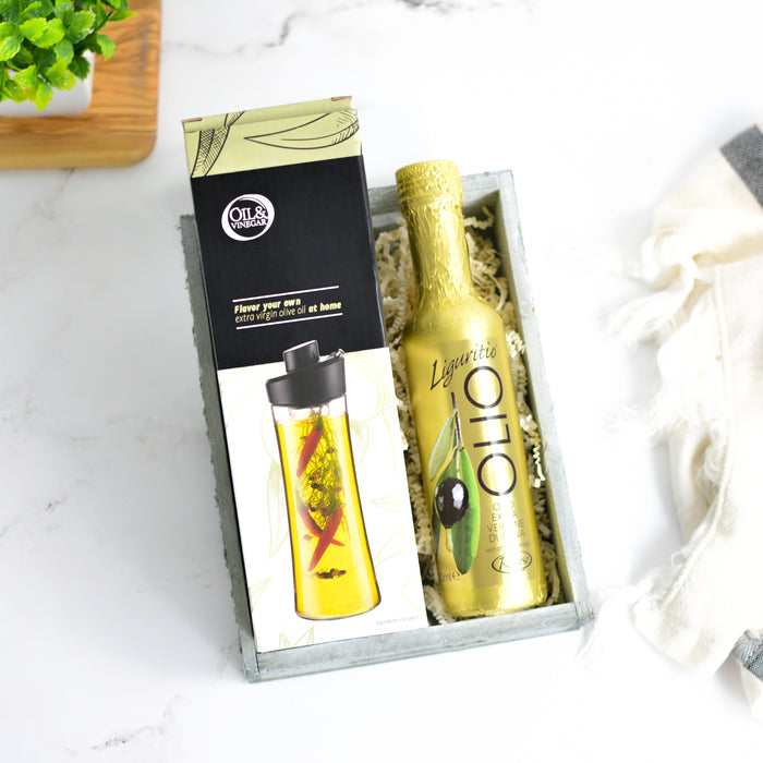 Gift set with a bottle on oil and packaged olive oil infuser on a marble surface
