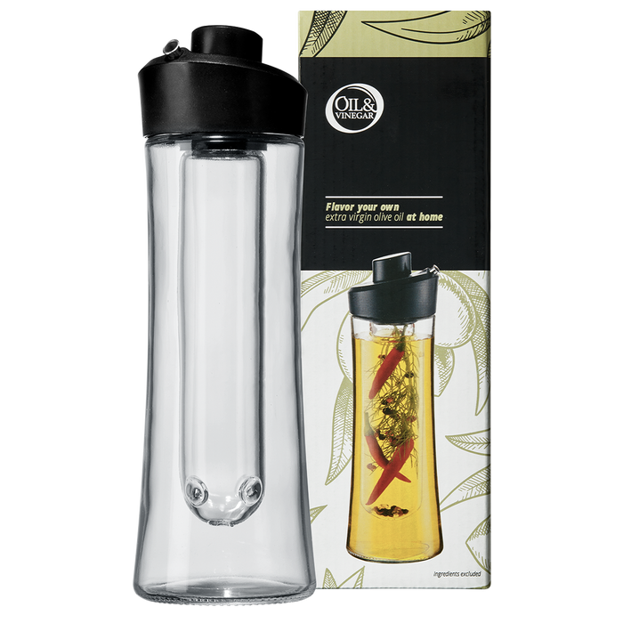 A clear glass herb oil infuser with a black plastic spout, alongside its packaging that features a picture of the infuser use with herbs inside.