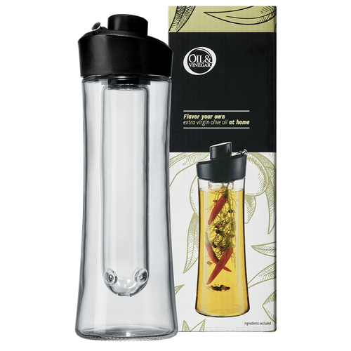 A clear glass herb oil infuser with a black plastic spout, alongside its packaging that features a picture of the infuser use with herbs inside.