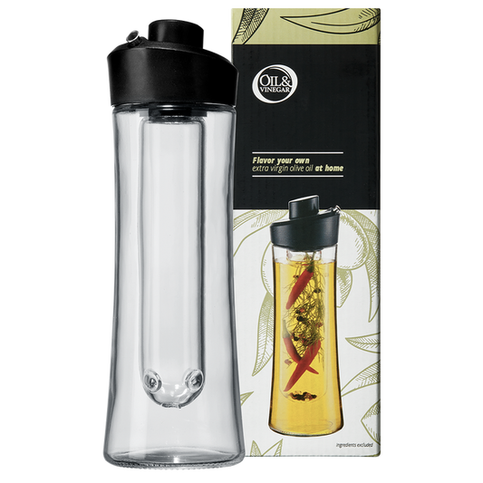 A clear glass herb oil infuser with a black plastic spout, alongside its packaging that features a picture of the infuser use with herbs inside.