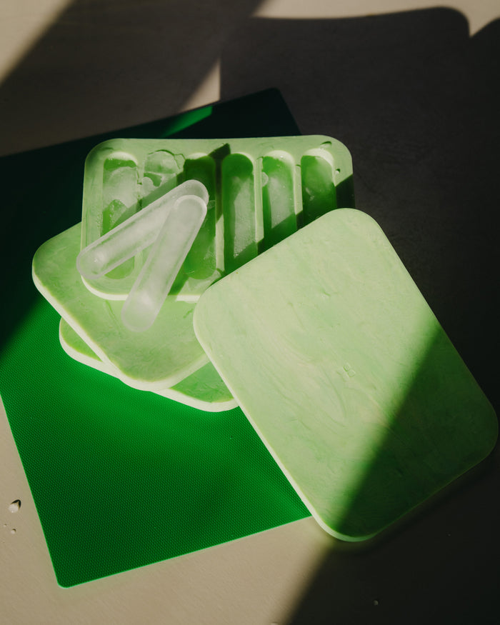Ice Tray with six ice sticks stacked on a green mat, ideal for perfectly chilled Microdrink.