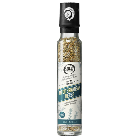 A clear glass bottle with a black lid containing ground Italian sea salt with Mediterranean herbs visible through the bottle, labeled 'MEDITERRANEAN HERBS'.