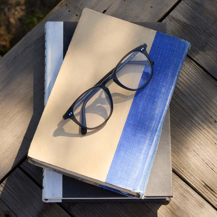 flat lay of diff eyewear jaxson prescription glasses in black laying on top of a book