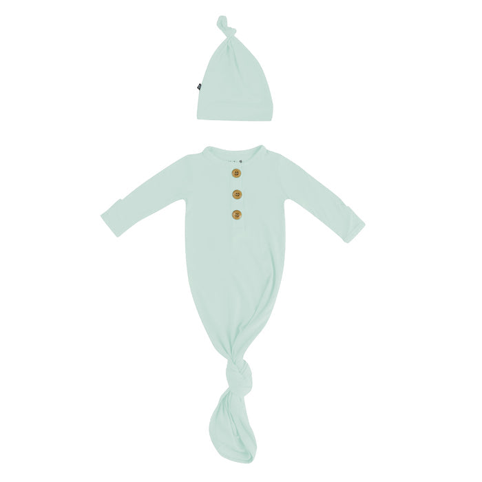 Flat lay of Kyte Baby Knotted Gown with Hat Set in Sage