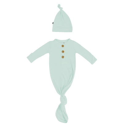 Flat lay of Kyte Baby Knotted Gown with Hat Set in Sage