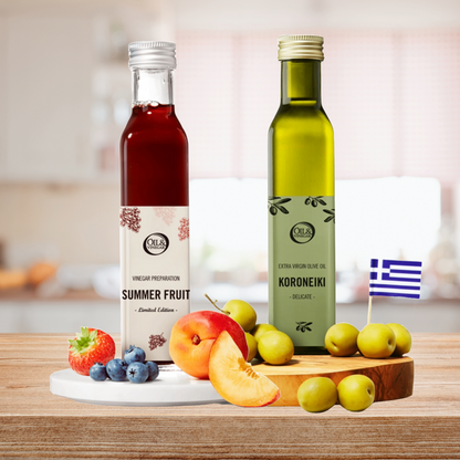 Two bottles of 'Summer Fruit' vinegar and 'Koroneiki' olive oil on a wooden board with fruits.