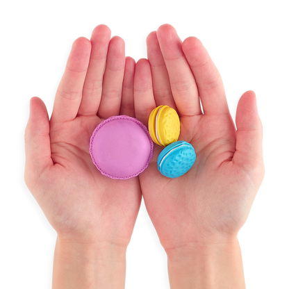 Three Le Macaron Patisserie Scented Erasers in persons hands