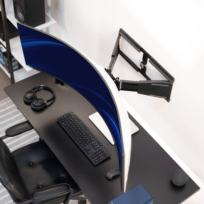 Modern office desk setup with chair, keyboard, mouse, and wall mounted ultrawide