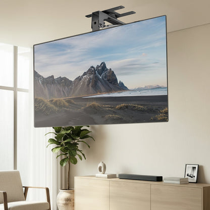 TV mounted on a Manual Flip Down TV Ceiling Mount displaying a mountain landscape in a living room.