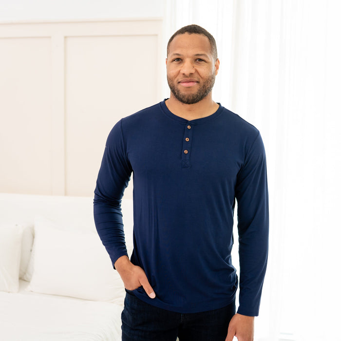 Man wearing Men's Long Sleeve Henley Top in Navy and jeans