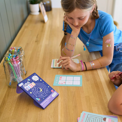 Kids playing card game from OOLY Mini Mazes Activity Cards set