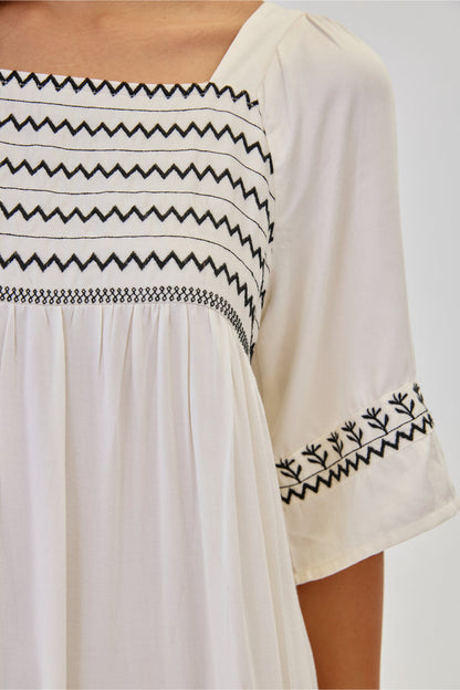 Close-up of black embroidery on NKN Nekane Jelani White Short Viscose Dress with 3/4 Sleeves and Bicolour Embroidery, shop nkn nekane at Dotique