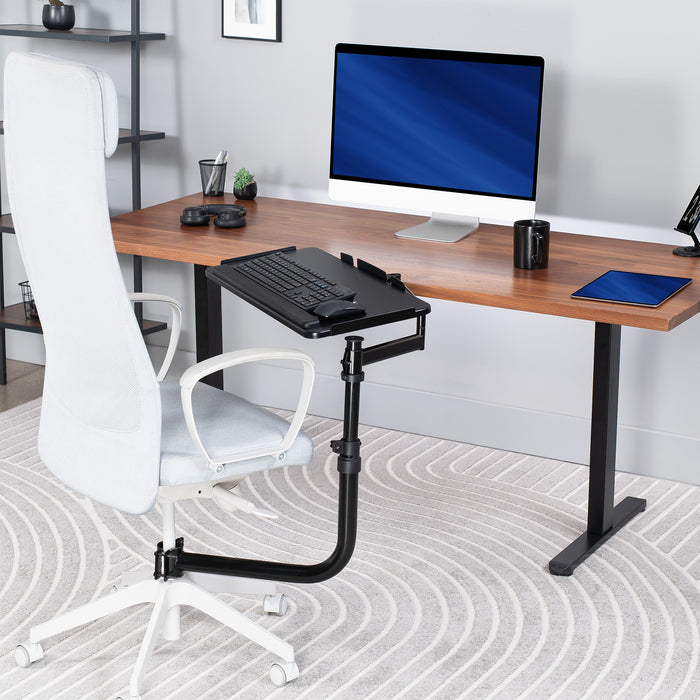 Walnut wood desktop on black desk frame with an adjustable office chair mounted premium keyboard tray on desk chair.
