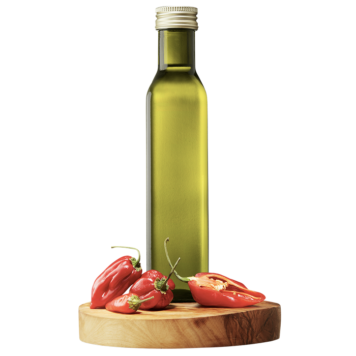A tall, slender bottle of Extra Virgin Olive Oil on a wooden board, flanked by fresh chili peppers.