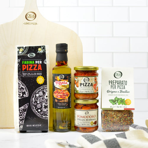 Collection of pizza-making ingredients and tools on a kitchen counter with a white tiled wall background.