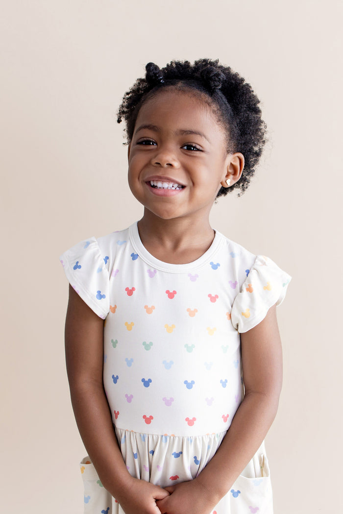 Girl wearing cream dress with pastel mickey head pattern
