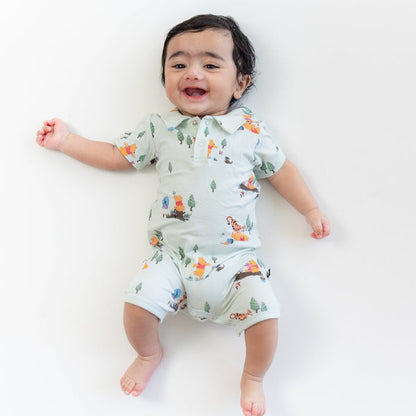 Smiling toddler wearing the Polo Shortall in Winnie the Pooh Hundred Acre Wood