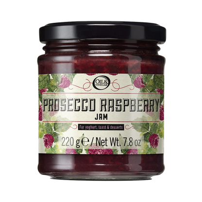 jar of prosecco raspberry jam with a label with raspberries and leaves drawings as decor with the product name and size of 7.8 ounces
