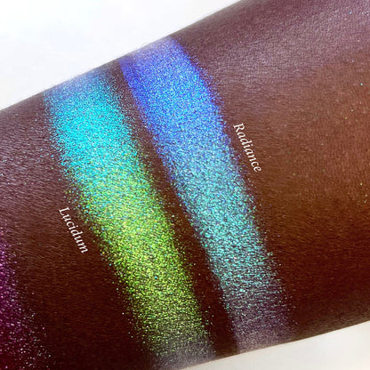 Top angled arm swatches on deep skin tone of Radiance Series 2 Iridescent Multichrome Eyeshadow shifts compared to Lucidum