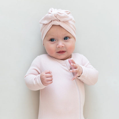Infant wearing Kyte Baby Ribbed turban style Headwrap in Blush