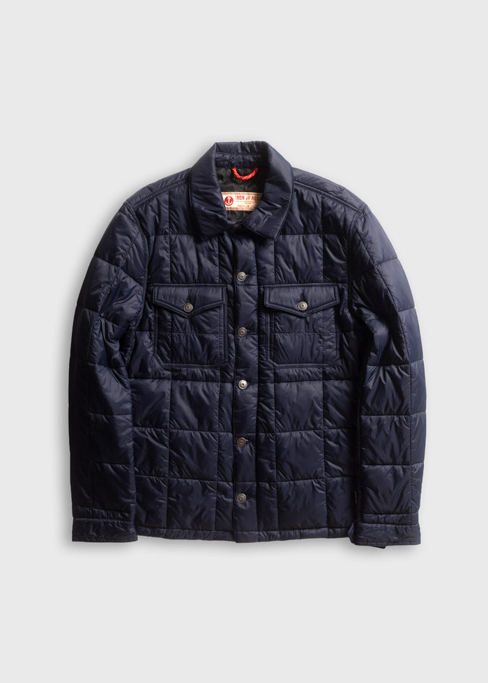 Navy quilted jacket with button closure, two chest pockets, and a collar, displayed on a plain white background.